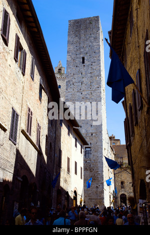 Italien Toskana San Gimignano Via di Querececchio voll von Touristen zu Fuß vorbei an Geschäften auf zwei der mittelalterlichen Türme der Stadt Stockfoto