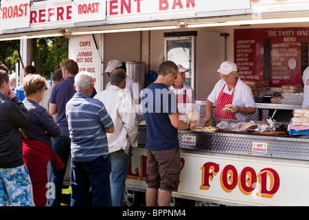 Schlange von Menschen, die Fast-Food von einem Butger und Hot Dog Stand auf einem Land fair kaufen Stockfoto