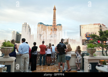 Bellagio-Brunnen: Von der Fortuna Bar aus beobachten Sie die Menschen, die die Brunnen des Bellagio Hotels vor dem Hintergrund des Paris Hotel, Las Vegas beobachten Stockfoto