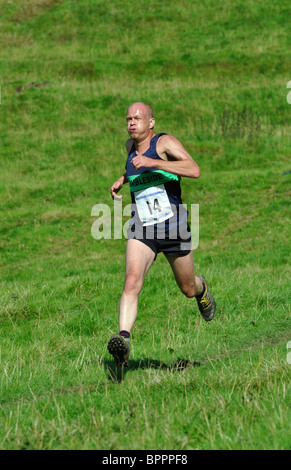 Fiel im Wettbewerb bei Grasmere Sports auf die erfahrenen Guides Race runner Stockfoto
