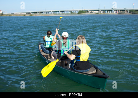 Mittelschule Mädchen das Tragen von Schwimmwesten Paddel ihr Kanu in Corpus Christi Bay bei marine Biologie Klasse Exkursion Stockfoto