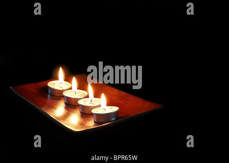Brennende Kerzen auf schwarzem Hintergrund isoliert. Stockfoto