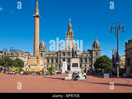 George Square im Zentrum von Glasgow mit Sir Walter Scott Statue links und Robert Burns Statue rechts und City Chambers hinten Stockfoto