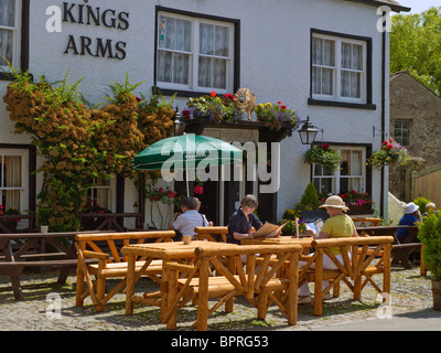 Leute, die vor dem Kings Arms Pub Public House sitzen Summer Devonshire Square Cartmel Village Cumbria England Vereinigtes Königreich Großbritannien GB Stockfoto