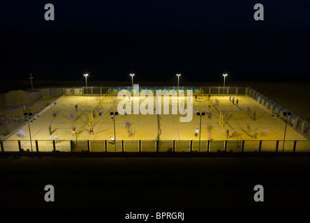 Menschen spielen Beach-Volleyball auf Plätzen und Flutlicht bei Nacht Brighton East Sussex England Stockfoto