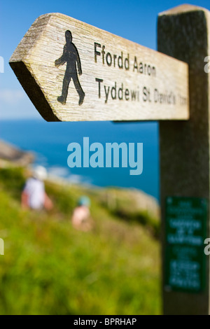 Wanderer auf dem Küstenpfad (mit Fußweg Zeichen) an St Davids Pembrokeshire Wales Stockfoto