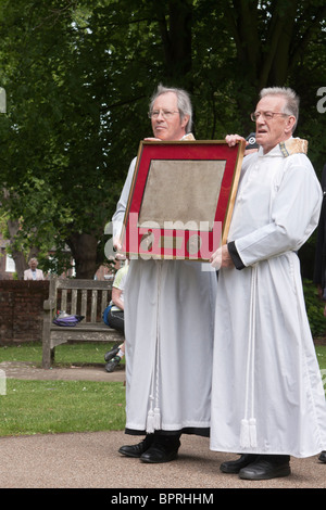 Zwei Männer in Mönchskutten tragen eine gerahmte Kopie der Magna Carta Stockfoto