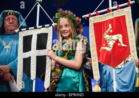 Junge Mädchen tragen Girlanden der Blumen hält Celtic Banner auf der Bühne während der Zeremonie bei National Eisteddfod of Wales 2010 Stockfoto