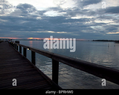 Untergehende Sonne in der Dämmerung auf der Indian River Lagune am Melbourne Beach Pier in Florida Stockfoto