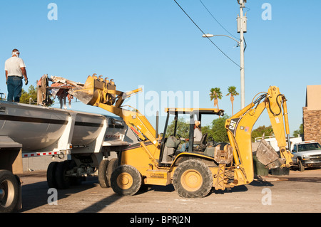 Ein Bagger wird eingesetzt, um Schmutz aus dem Abbruch eines alten Geschäftshauses. Stockfoto