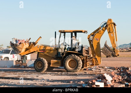 Ein Bagger wird eingesetzt, um Schmutz aus dem Abbruch eines alten Geschäftshauses. Stockfoto