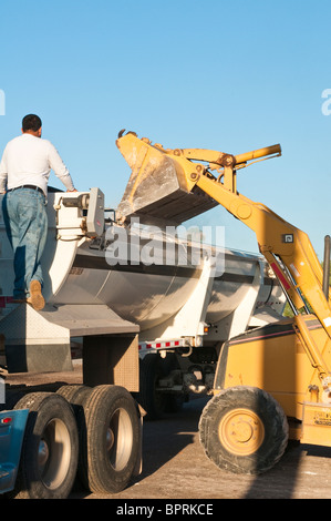 Ein Bagger wird eingesetzt, um Schmutz aus dem Abbruch eines alten Geschäftshauses. Stockfoto