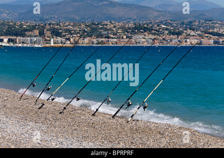 Fischer, die Teilnahme an einer Reihe von Beachcaster Angelruten auf einem Kiesstrand. Stockfoto