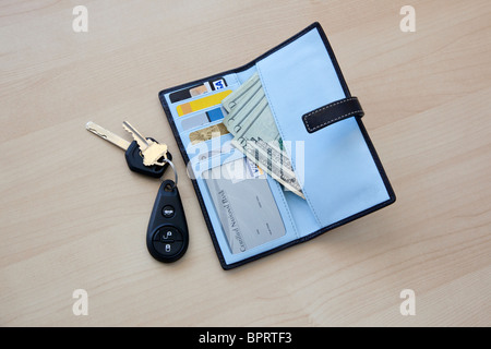 Portemonnaie mit Geld und Karten und Auto Schlüssel auf Tisch Stockfoto