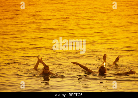 Menschen schweben im Toten Meer bei Sonnenuntergang, Jordanien Stockfoto