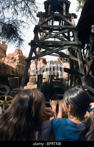 Zwei Mädchen fahren auf dem Beifahrersitz eine Holzachterbahn, Disneyland Resort Anaheim, California, Vereinigte Staaten von Amerika. Stockfoto