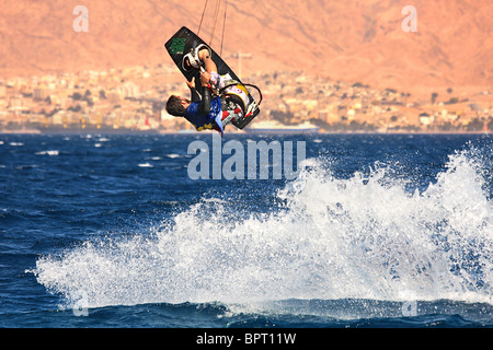 Nicht identifizierte Kitesurfer springt über das Wasser beim Surfen am Roten Meer auf beliebte touristische Stadt Eilat. Stockfoto