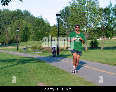 Mann, jogging auf dem Radweg, der parallel zur Gouin Boulevard, in Montreal, Quebec, Kanada Stockfoto