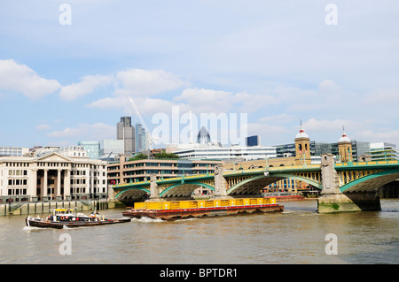 Ein Schlepper Abschleppen ein Schiff mit Containern vorbei Southwark Bridge, London, England, UK Stockfoto