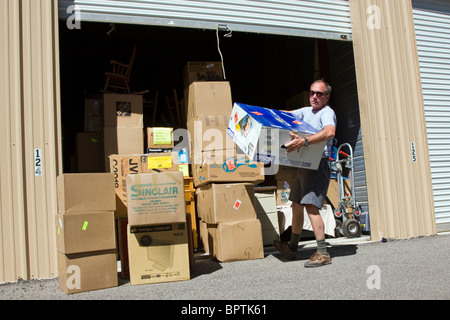 Mann, Kisten mit Sachen aus einem Self-Storage Space entfernen. Stockfoto