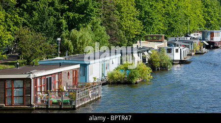 Hausboote in Amsterdam am Fluss Amstel, mit schwimmenden Gärten und Terrassen oder Balkone. Stockfoto