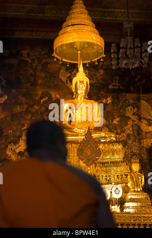 Ein Mönch kniet vor einer Buddha-Statue im Wat Po, Grand Palace, Bangkok, Thailand. Indochina. Südost-Asien. Januar 2010 Stockfoto