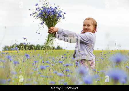 Kleines Mädchen Blau Blumen zu pflücken, in einem Feld Stockfoto