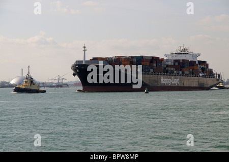 Die Bangkok Express mit Schleppern in Anwesenheit Abfahrt Hafen Southampton England UK Stockfoto