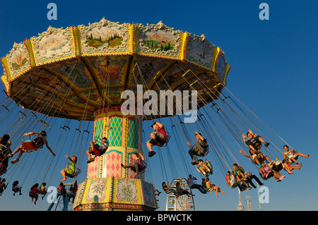 Kinder auf dem antiken Spinnerei Schaukel fahren bei Sonnenuntergang an der Toronto kanadische nationale Ausstellung CNE Kirmes auf halbem Weg fairgrounds Stockfoto