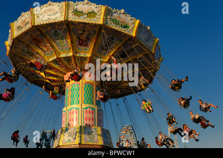 Kinder auf dem klassischen Spinning swing Fahrt bei Sonnenuntergang an der Toronto cne Stockfoto