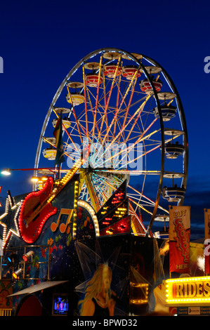 Musikalische Unterhaltung und Riesenrad fährt an der Canadian National Exhibition CNE Kirmes auf halbem Weg Fairgrounds Toronto in der Abenddämmerung Stockfoto