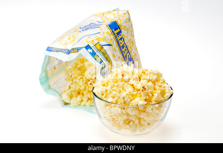 Beutel der Pop Secret Mikrowelle Popcorn mit etwas Popcorn in Glasschale auf weißem Hintergrund geöffnet, Ausschnitt. Stockfoto