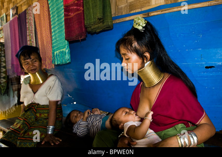 Ein Padong Longneck Frau stillen ihr Baby im Flüchtlingslager an der Thai-burmesischen Grenze gelegen. Stockfoto