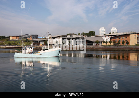 Ein Fischerboot auf das Meer auf dem Fluss unterwegs tragen mit der Universität von Sunderland im Hintergrund. England, UK Stockfoto