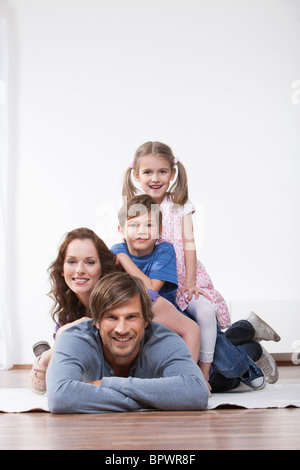 Glückliche Familie auf Teppich Stockfoto