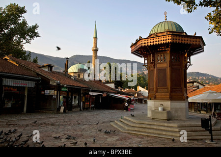 Ein Quadrat in Sarajevo Altstadt Bascarsija Bezirk, zeigt der Sebilj und das Minarett der Gazi-Husrev-beg-Moschee Stockfoto