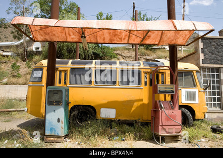 Reisen, gelbe Wohnmobil und verlassene alte Benzin / Gas in einer Station mit rot und blau Pumpen in Armenien. Stockfoto