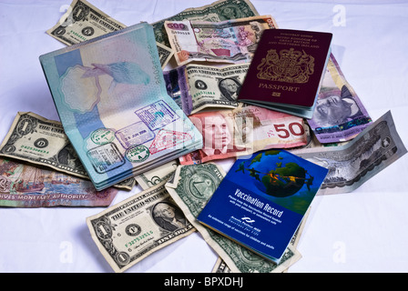 Vereinigtes Königreich-Pässe und Impfung Bücher Verlegung auf verschiedene Banknoten aus der ganzen Welt, einschließlich US-Dollar. Stockfoto