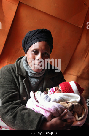 Mutter mit ihrem Baby in ihrer Hütte in einem Township in den Weinbergen von De Doorns, Western Cape, South Africa, Hex Valley Stockfoto