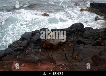 Eine alte, verrostet Stück des metallischen Papierkorb Würfe die Ufer des Glas-Strand in Hawaii. Glass Beach war einer ehemaligen Müllhalde. Stockfoto