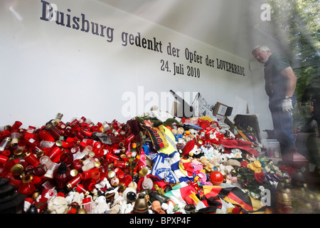 Duisburg Loveparade 2010: Glaskubus auf dem Gelände der Tragödie in die Trauer Geschenke, Kerzen und Spielzeug daran gehalten werden Stockfoto