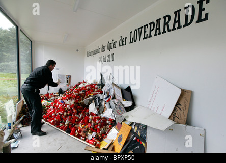 Duisburg Loveparade 2010: Glaskubus auf dem Gelände der Tragödie in die Trauer Geschenke, Kerzen und Spielzeug daran gehalten werden Stockfoto