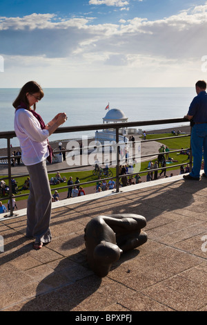 Eine Frau fotografiert eine Antony Gormley Skulptur in der "Masse"-Ausstellung, Dach des De La Warr Pavilion, Bexhill, East Sussex, Großbritannien während der 75. Aniverssary feiern Stockfoto