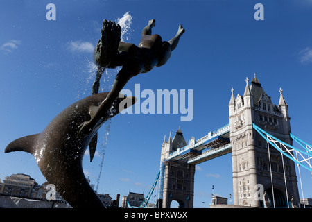 Mädchen mit einem Delfin von David Wynne & Tower Bridge, St Katherine's Dock, London, UK. Stockfoto