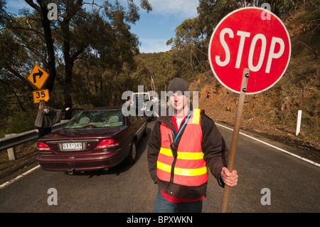 Ein Straßenarbeiter mit einem Stop-Schild auf der Great Ocean Road in der Nähe von Lorne in Victoria Australien Stockfoto