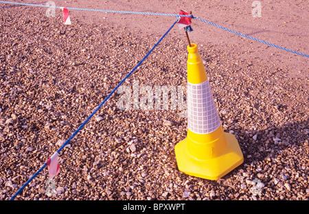 Gelbe Verkehr Kegel mit blauen Nylon Seile zeigt keinen Zugang oder Parkplatz auf Schotter Fläche Stockfoto