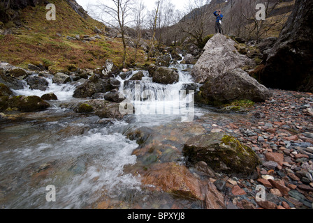 Eine Walker nimmt ein Foto in der Nähe eine Reihe von Miniatur-Wasserfälle auf dem Weg bis zu den versteckten Tal in Glencoe, Schottland Stockfoto