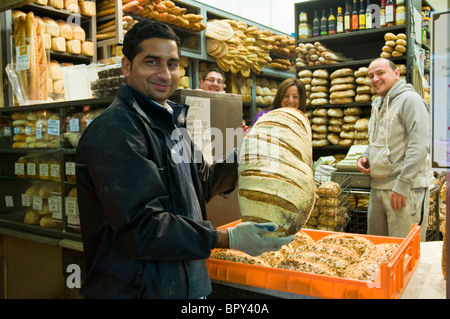 Mann holt am frühen Morgen knuspriges Brot aus einer Bäckerei ab, um es an Einzelhandelsgeschäfte am Queen Victoria Market in Melbourne, Australien, zu liefern Stockfoto