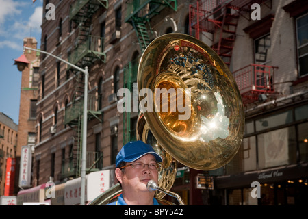 Ein Mitglied einer Blaskapelle spielt seine Sousaphon marschiert durch die Straßen von Chinatown in New York Stockfoto