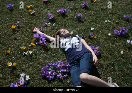 Ahhh Jugend! A, ein junges Mädchen saugt die Sonne keine Sorge in der Welt inmitten von Blumen blühen auf einer Wiese. Stockfoto